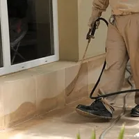 General pest control technician spraying exterior perimeter around a home in Columbus, OH